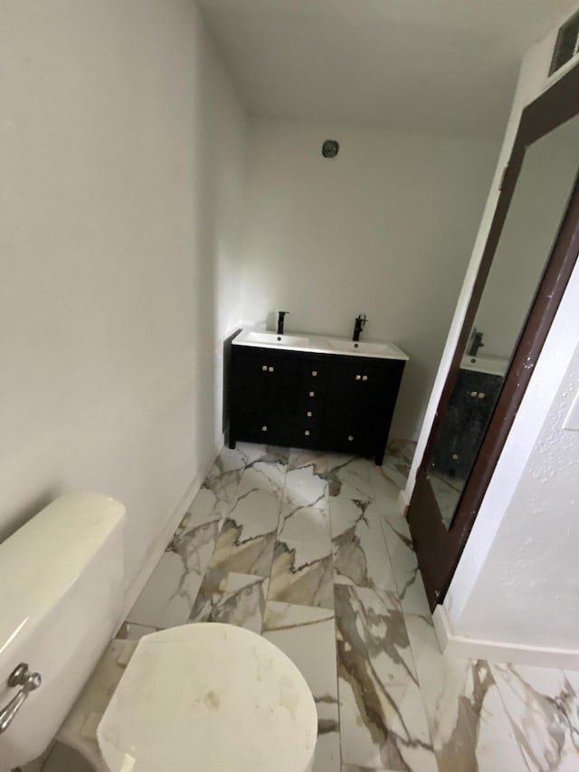 4235 Clay St, Marianna, FL 32446 - bathroom featuring marble look tile flooring, toilet, and double vanity