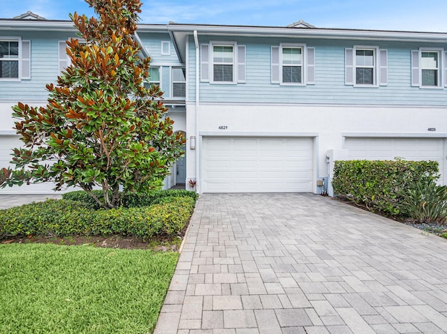 4829 Pointe Midtown Rd Unit 4829, Palm Beach Gardens, FL 33418 - view of front facade with an attached garage, decorative driveway, and stucco siding