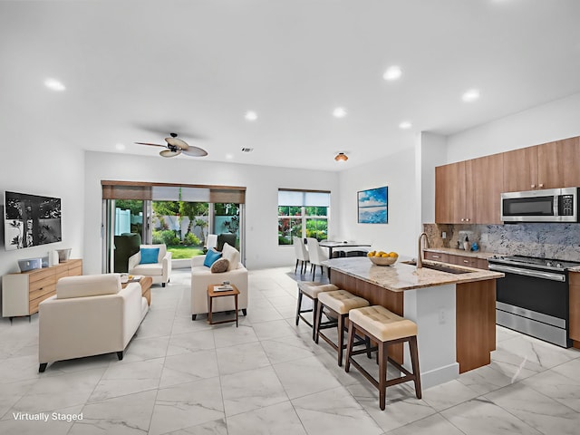 4829 Pointe Midtown Rd Unit 4829, Palm Beach Gardens, FL 33418 - kitchen featuring stainless steel appliances, light marble finish flooring, a sink, a breakfast bar area, and light stone countertops