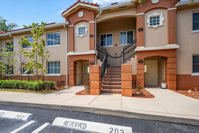 3710 N Jog Rd Unit 202, West Palm Beach, FL 33411 - view of property with uncovered parking and stairs