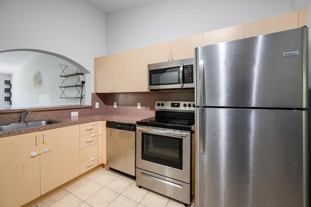 3710 N Jog Rd Unit 202, West Palm Beach, FL 33411 - kitchen with stainless steel appliances, a sink, decorative backsplash, light tile patterned flooring, and light brown cabinetry