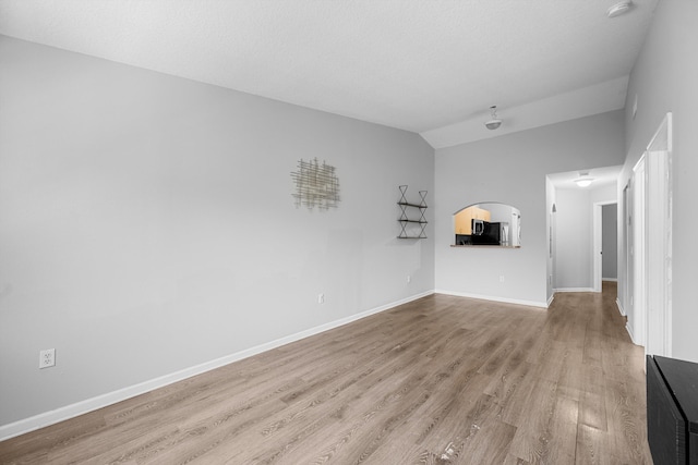 3710 N Jog Rd Unit 202, West Palm Beach, FL 33411 - unfurnished living room with wood finished floors, baseboards, and lofted ceiling