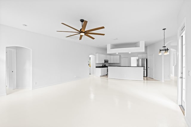 11356 Ira Ln, Lake Worth, FL 33449 - unfurnished living room with arched walkways, a ceiling fan, finished concrete flooring, and a chandelier