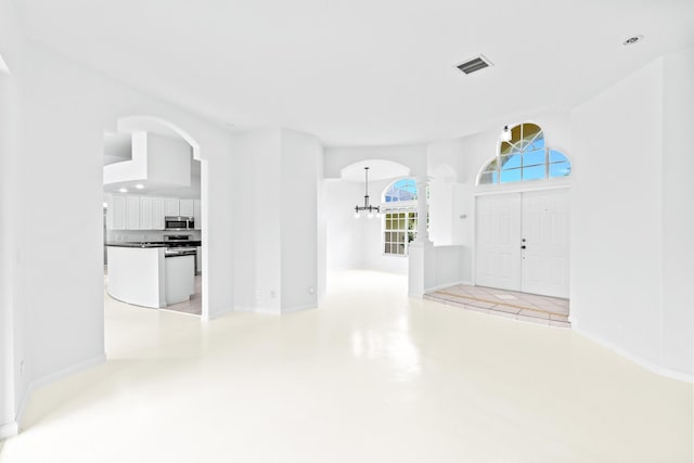 11356 Ira Ln, Lake Worth, FL 33449 - entryway featuring a chandelier, arched walkways, and baseboards
