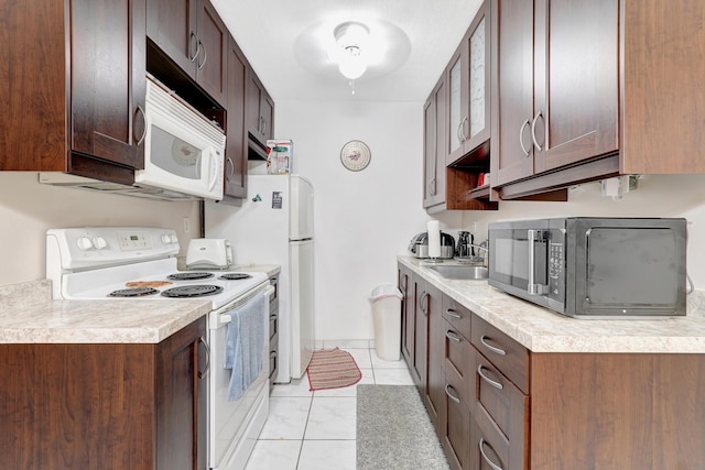 15610 NE 6th Ave NE Unit 10C, Miami, FL 33162 - kitchen with white appliances, a sink, light countertops, light tile patterned floors, and dark brown cabinets
