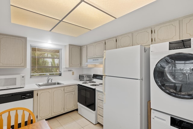 13623 Via Aurora Unit C, Delray Beach, FL 33484 - kitchen featuring white appliances, under cabinet range hood, stacked washer and clothes dryer, a sink, and light tile patterned floors