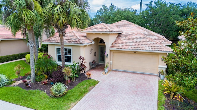 7144 Maidstone Dr, Port Saint Lucie, FL 34986 - mediterranean / spanish-style house featuring stucco siding, a garage, decorative driveway, and a tiled roof