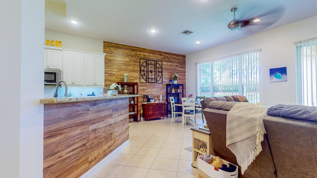 7144 Maidstone Dr, Port Saint Lucie, FL 34986 - living room with healthy amount of natural light, recessed lighting, light tile patterned floors, and wood walls