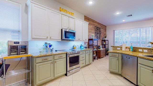 7144 Maidstone Dr, Port Saint Lucie, FL 34986 - kitchen featuring appliances with stainless steel finishes, healthy amount of natural light, tasteful backsplash, recessed lighting, and white cabinetry