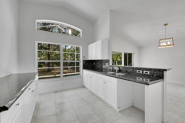 5365 NW 49th St, Coconut Creek, FL 33073 - kitchen with a sink, a peninsula, light tile patterned floors, white cabinetry, and high vaulted ceiling