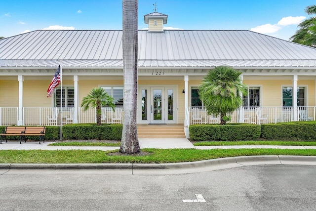 1463 N Jeaga Dr, Jupiter, FL 33458 - back of house featuring a porch, metal roof, and a chimney