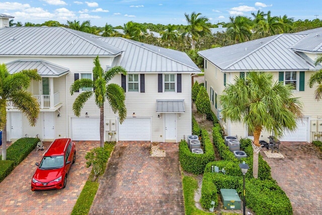 1463 N Jeaga Dr, Jupiter, FL 33458 - view of front facade with driveway, an attached garage, and metal roof