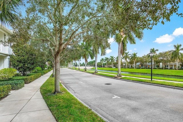 1463 N Jeaga Dr, Jupiter, FL 33458 - view of asphalt road featuring sidewalks, curbs, a water view, and street lighting
