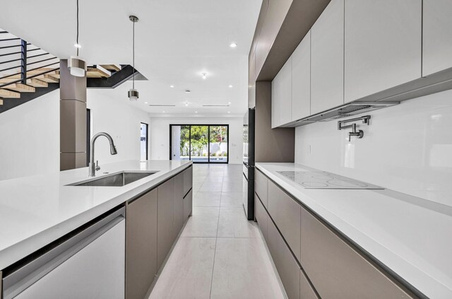 1233 NE 12th Ave Unit A, Fort Lauderdale, FL 33304 - kitchen with a sink, modern cabinets, white electric cooktop, dishwasher, and light countertops
