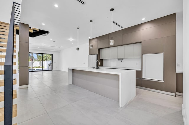 1233 NE 12th Ave Unit A, Fort Lauderdale, FL 33304 - kitchen featuring freestanding refrigerator, modern cabinets, light countertops, recessed lighting, and a large island with sink