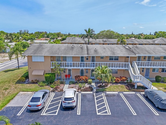 2121 NE 1st Ct Unit 202, Boynton Beach, FL 33435 - view of building exterior with uncovered parking and stairs