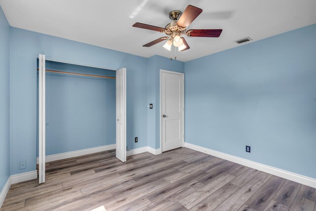 165 Cordoba Cir, Royal Palm Beach, FL 33411 - unfurnished bedroom featuring wood finished floors, baseboards, a ceiling fan, and a closet