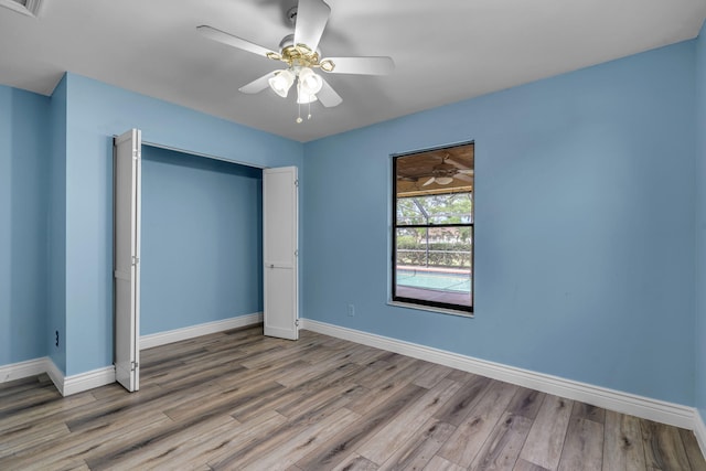 165 Cordoba Cir, Royal Palm Beach, FL 33411 - unfurnished bedroom featuring wood finished floors, baseboards, ceiling fan, and a closet