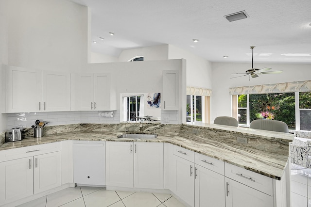 6078 Slice Ct, Boynton Beach, FL 33437 - kitchen featuring vaulted ceiling, a sink, light tile patterned floors, light stone countertops, and white cabinets