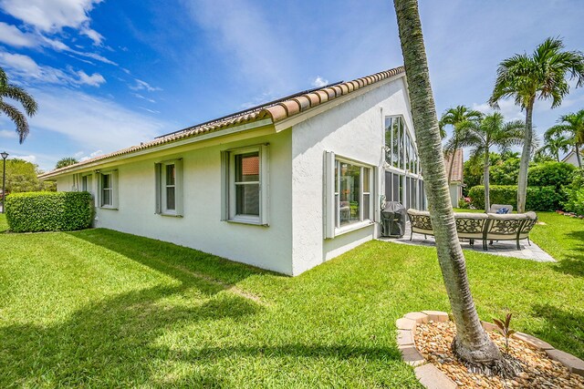 6078 Slice Ct, Boynton Beach, FL 33437 - view of side of property with stucco siding, a lawn, a patio, an outdoor living space, and a tile roof