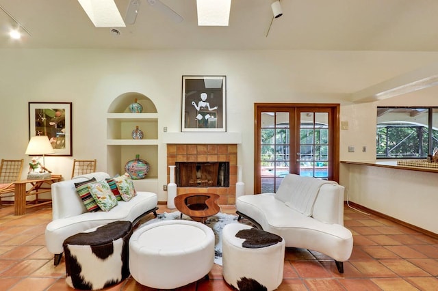 11357 Roselynn Way, Lake Worth, FL 33449 - tiled living room with a skylight, built in features, a tiled fireplace, baseboards, and track lighting