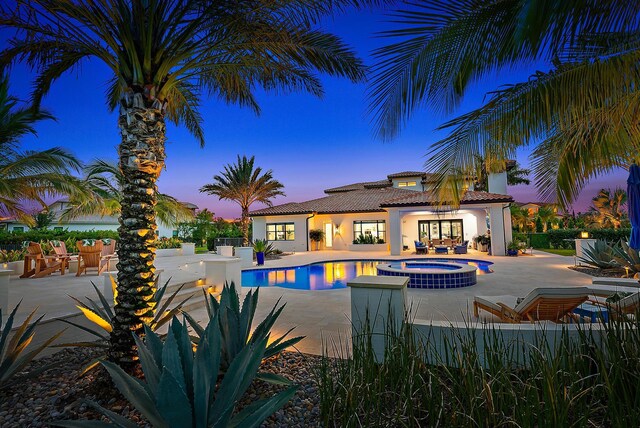 8164 SE Old Plantation Cir, Jupiter, FL 33458 - pool at dusk with an in-ground hot tub and a patio area