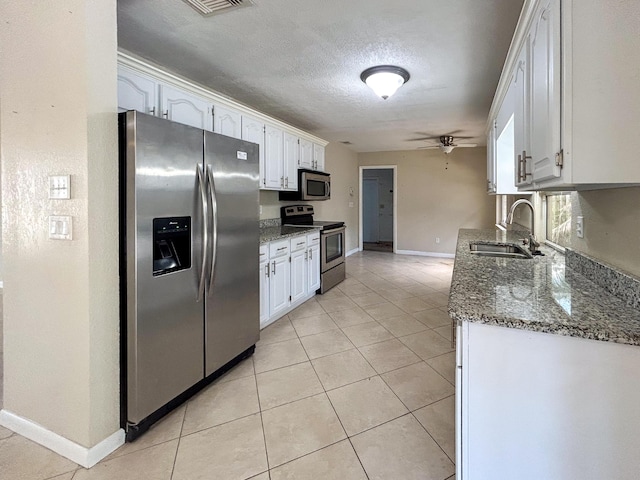 1712 SW Airoso Blvd, Port Saint Lucie, FL 34984 - kitchen featuring appliances with stainless steel finishes, ceiling fan, a sink, white cabinets, and dark stone counters