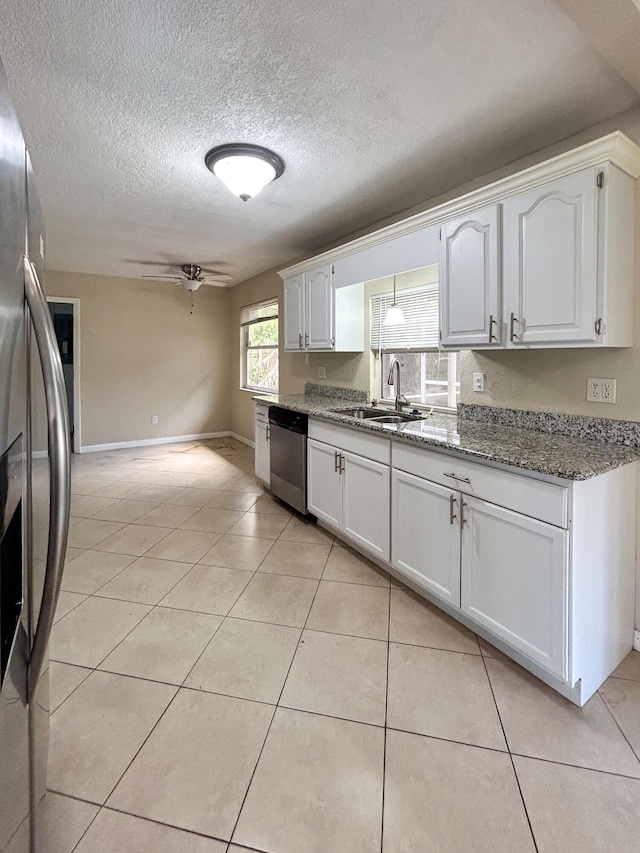 1712 SW Airoso Blvd, Port Saint Lucie, FL 34984 - kitchen with appliances with stainless steel finishes, a sink, a ceiling fan, stone countertops, and white cabinets