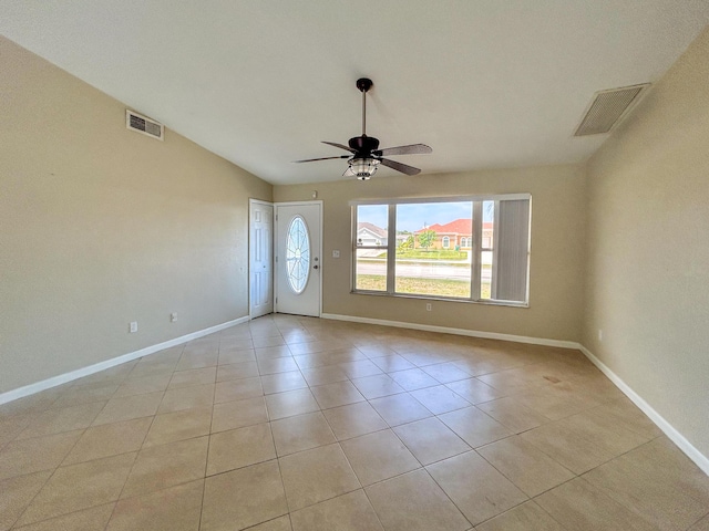 1712 SW Airoso Blvd, Port Saint Lucie, FL 34984 - empty room featuring a ceiling fan, baseboards, light tile patterned floors, and vaulted ceiling
