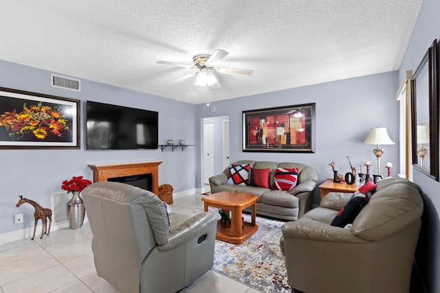 437 Pine Glen Ln Unit B-2, Greenacres, FL 33463 - living room featuring ceiling fan, light tile patterned floors, a textured ceiling, a glass covered fireplace, and baseboards