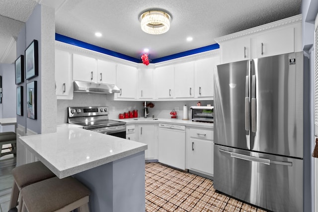 437 Pine Glen Ln Unit B-2, Greenacres, FL 33463 - kitchen with appliances with stainless steel finishes, under cabinet range hood, a peninsula, a textured ceiling, and white cabinets