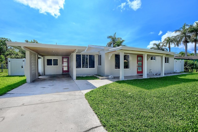126 NW 3rd Ct, Boca Raton, FL 33432 - view of front facade featuring stucco siding, driveway, covered porch, and an attached carport