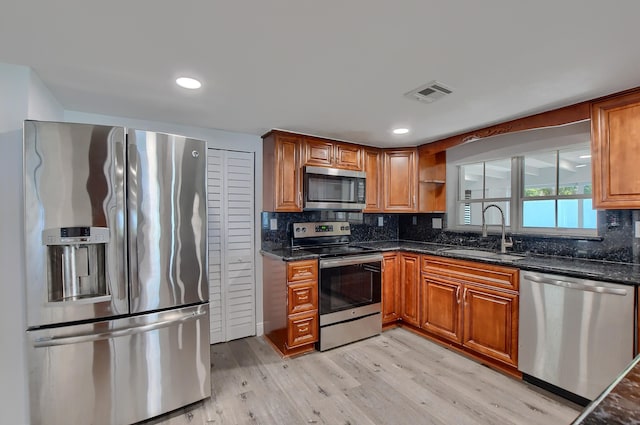 126 NW 3rd Ct, Boca Raton, FL 33432 - kitchen featuring stainless steel appliances, a sink, light wood-style floors, brown cabinetry, and recessed lighting