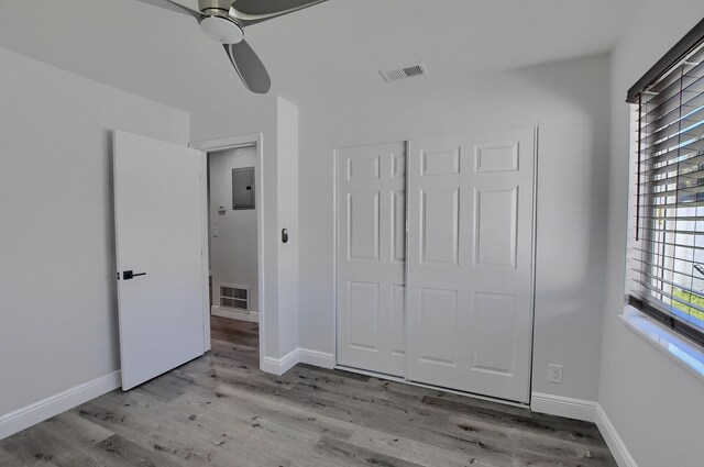 126 NW 3rd Ct, Boca Raton, FL 33432 - unfurnished bedroom with electric panel, wood finished floors, ceiling fan, and baseboards