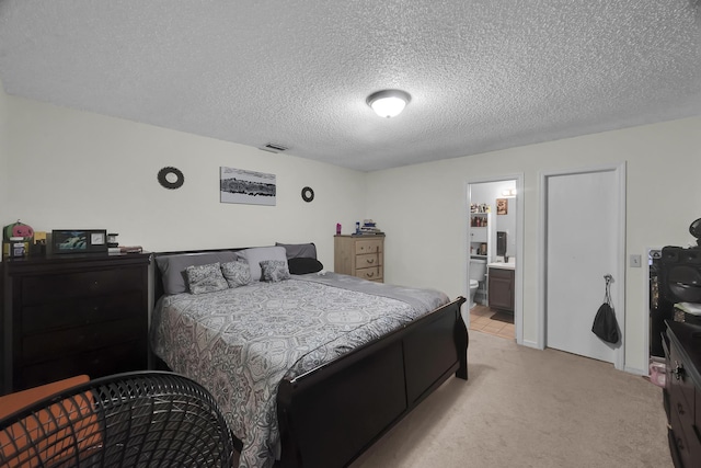 1352 SW Halford Ave, Port Saint Lucie, FL 34953 - bedroom with light carpet, a textured ceiling, and ensuite bath