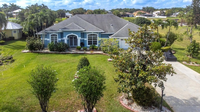 2608 SW River Shore Dr, Port Saint Lucie, FL 34984 - view of front of house with a front yard, stucco siding, and driveway