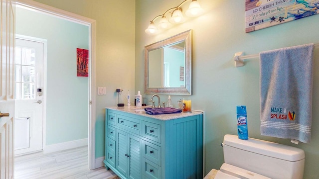 2608 SW River Shore Dr, Port Saint Lucie, FL 34984 - bathroom with toilet, vanity, wood finished floors, and baseboards