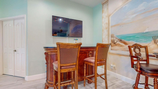 2608 SW River Shore Dr, Port Saint Lucie, FL 34984 - dining space with a dry bar, wood finished floors, and baseboards