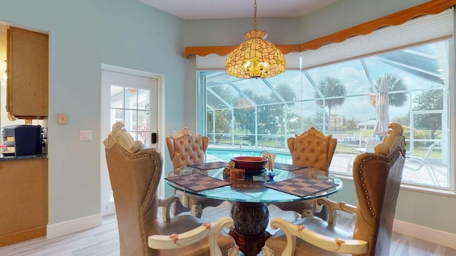 2608 SW River Shore Dr, Port Saint Lucie, FL 34984 - dining area featuring a sunroom, baseboards, and light wood finished floors