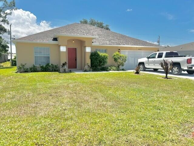 8065 99th Ct, Vero Beach, FL 32967 - view of front of home with an attached garage, stucco siding, and a front lawn
