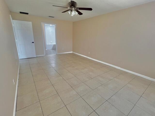 8065 99th Ct, Vero Beach, FL 32967 - spare room featuring ceiling fan and light tile patterned floors