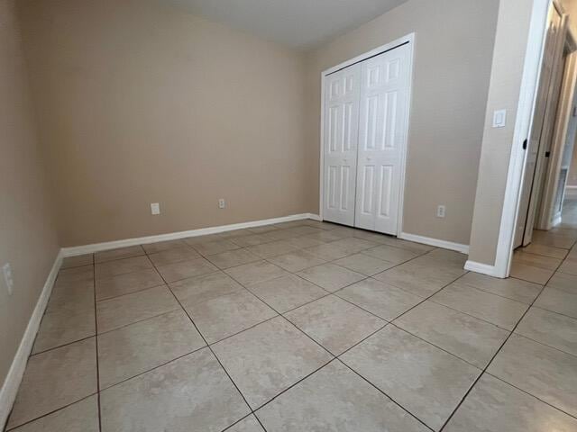 8065 99th Ct, Vero Beach, FL 32967 - unfurnished bedroom with light tile patterned floors and a closet