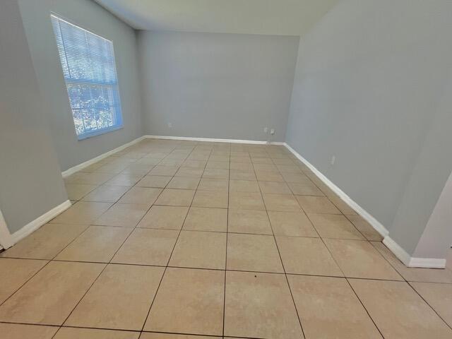 8065 99th Ct, Vero Beach, FL 32967 - spare room with light tile patterned floors and baseboards