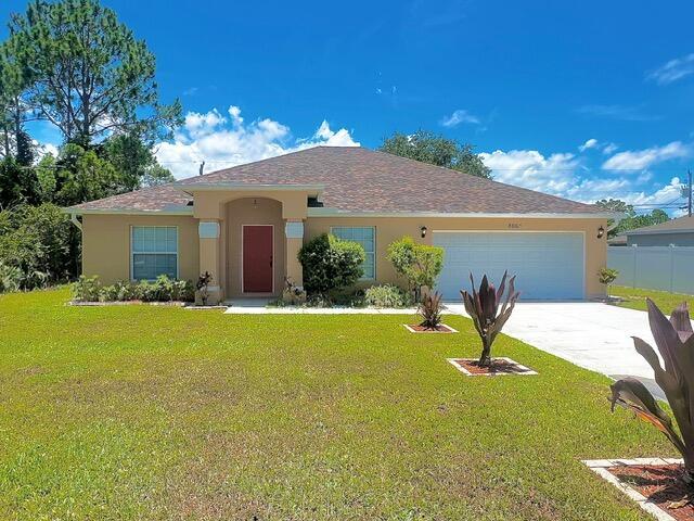 8065 99th Ct, Vero Beach, FL 32967 - view of front facade featuring stucco siding, a garage, and concrete driveway
