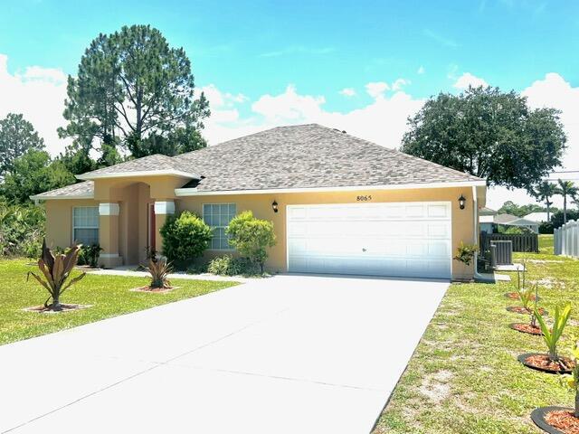 8065 99th Ct, Vero Beach, FL 32967 - single story home featuring a garage, concrete driveway, and stucco siding