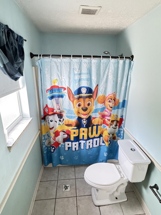7810 Santa Clara Blvd, Fort Pierce, FL 34951 - full bath featuring toilet, tile patterned floors, a textured ceiling, a shower with curtain, and baseboards