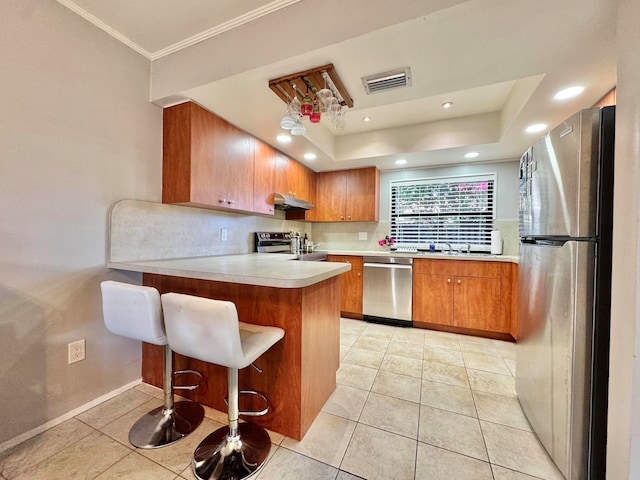 15015 SW 49th Ln Unit A-113, Miami, FL 33185 - kitchen with appliances with stainless steel finishes, brown cabinetry, under cabinet range hood, light tile patterned floors, and light countertops