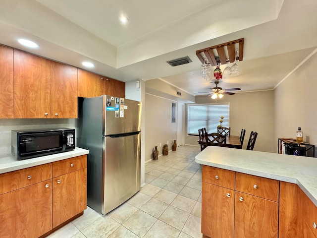 15015 SW 49th Ln Unit A-113, Miami, FL 33185 - kitchen with freestanding refrigerator, black microwave, ceiling fan, light countertops, and brown cabinets