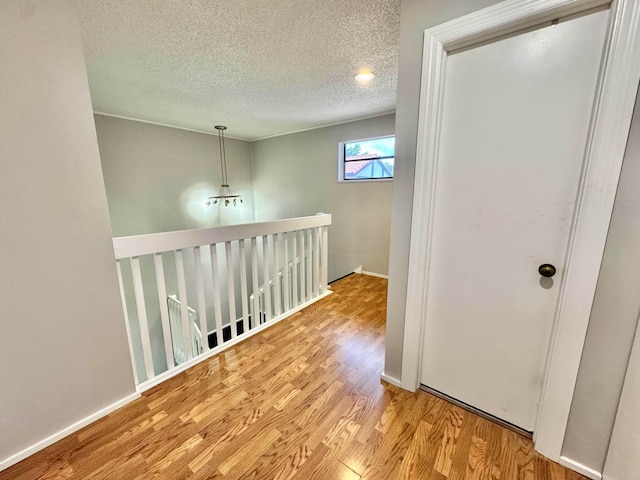 15015 SW 49th Ln Unit A-113, Miami, FL 33185 - hallway featuring wood finished floors, a textured ceiling, and baseboards