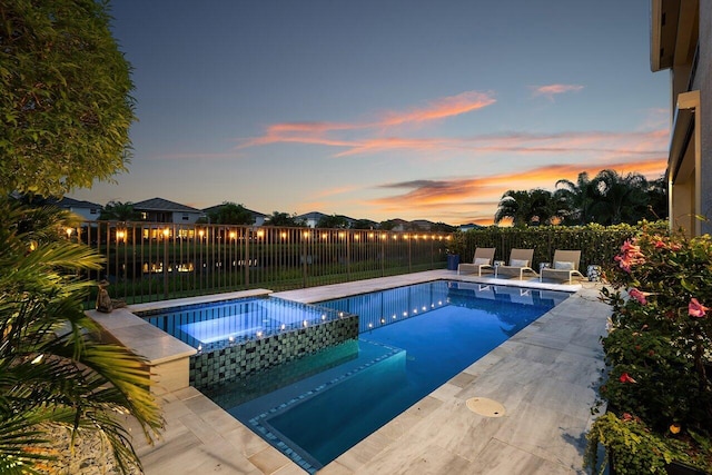 9657 Sterling Shores St, Delray Beach, FL 33446 - pool at dusk featuring a fenced backyard, a patio area, and a pool with connected hot tub
